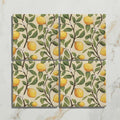 Set of four Studio Nonna kitchen Sorrento Sabbia ceramic coasters with yellow lemon and green leaf pattern on off-white background
