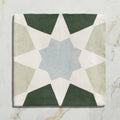 Square ceramic tile with geometric star pattern in muted green beige and light blue tones from Studio Souk Blue Star Ceramic