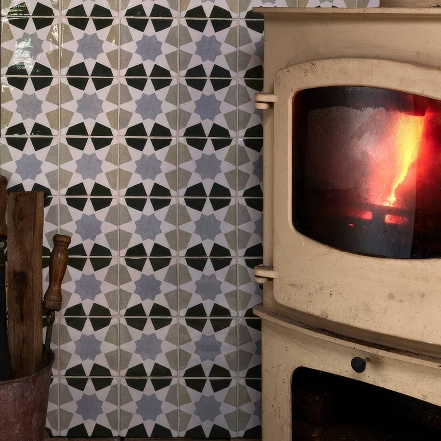 Cream-colored ceramic wood-burning stove studio souk blue star with glass door showing glowing orange embers inside
