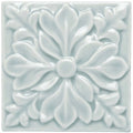 A white glossy square ceramic tile with embossed floral design featuring symmetrical petals and leaf motifs Sudbury Hampstead