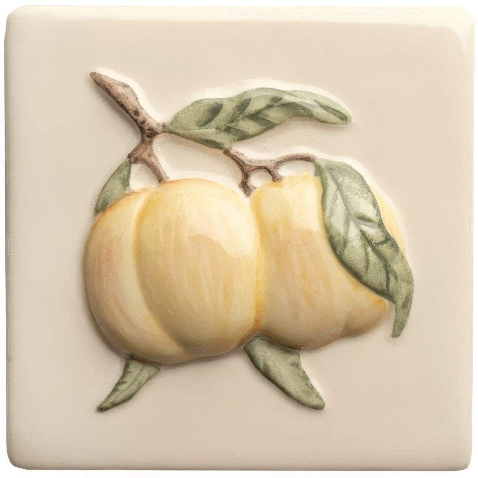Cream-colored ceramic tile with raised three-dimensional relief of pale yellow peaches green leaves and brown stems