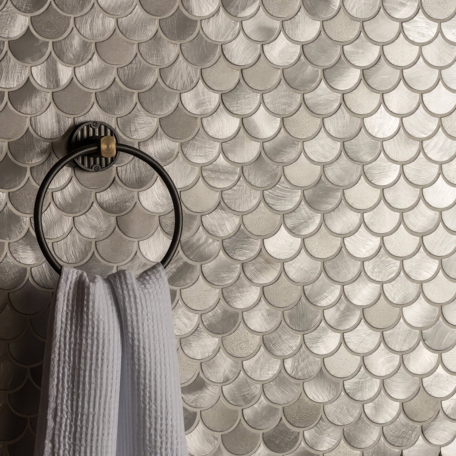 Surtur silver brushed scale aluminium mosaic tile wall in silver with black towel ring holding white textured towel