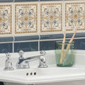 Chrome-finished three-handle bathroom faucet with ornate rounded knobs and polished metallic finish on county white tile