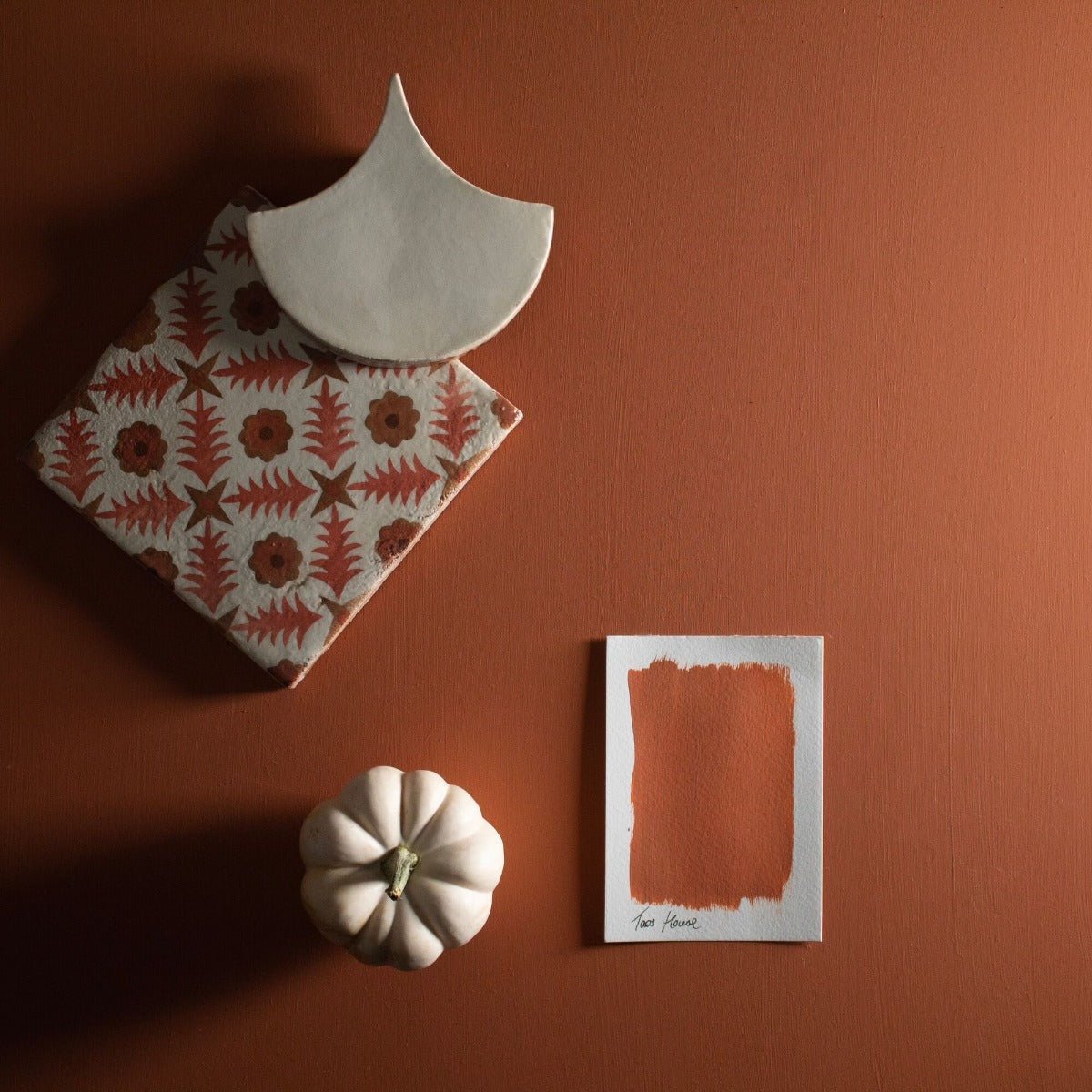 A white ceramic pumpkin with textured segments and a small green stem from taos house collection