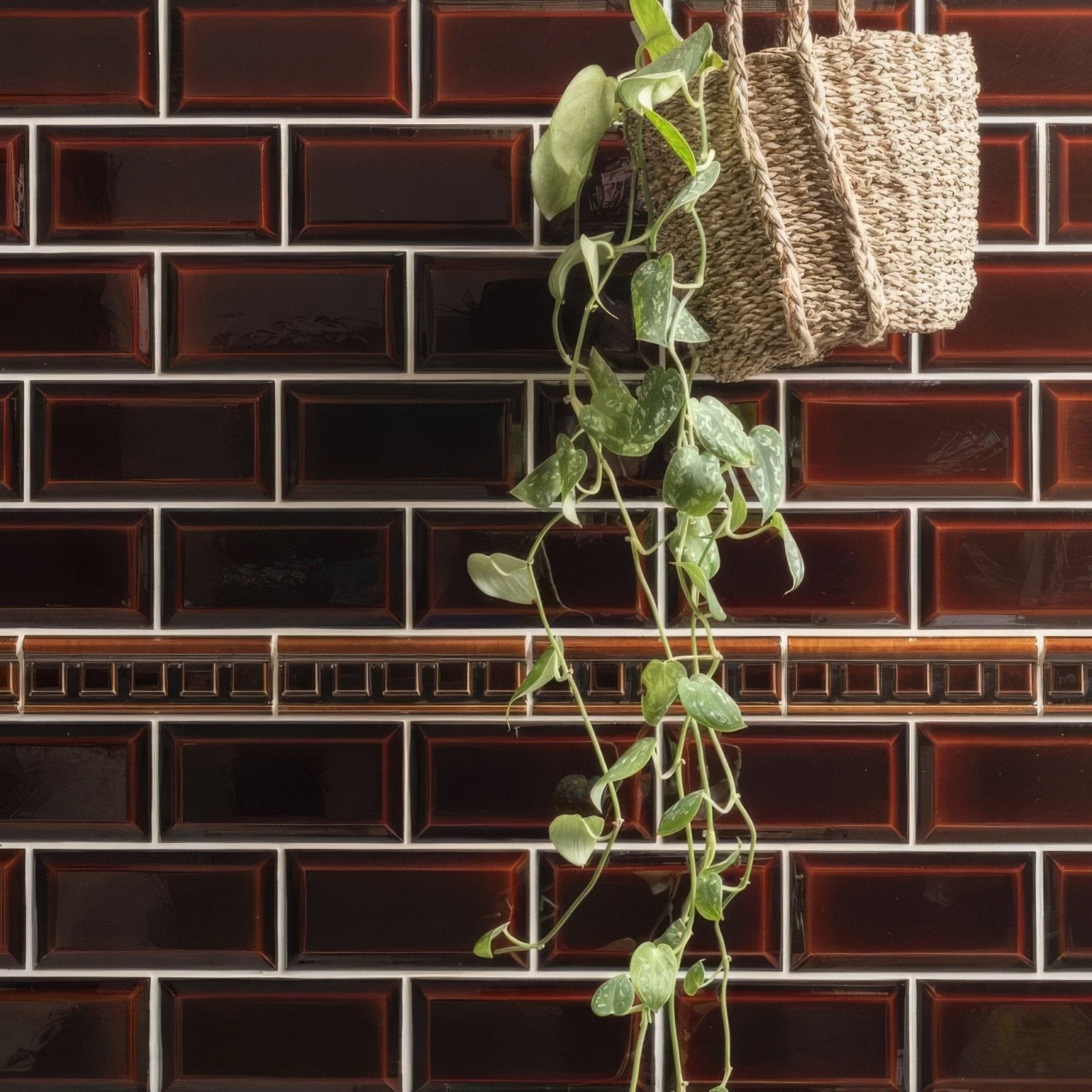 A natural woven wicker hanging basket with a trailing green vine plant complements the teapot brown metro bevelled tile