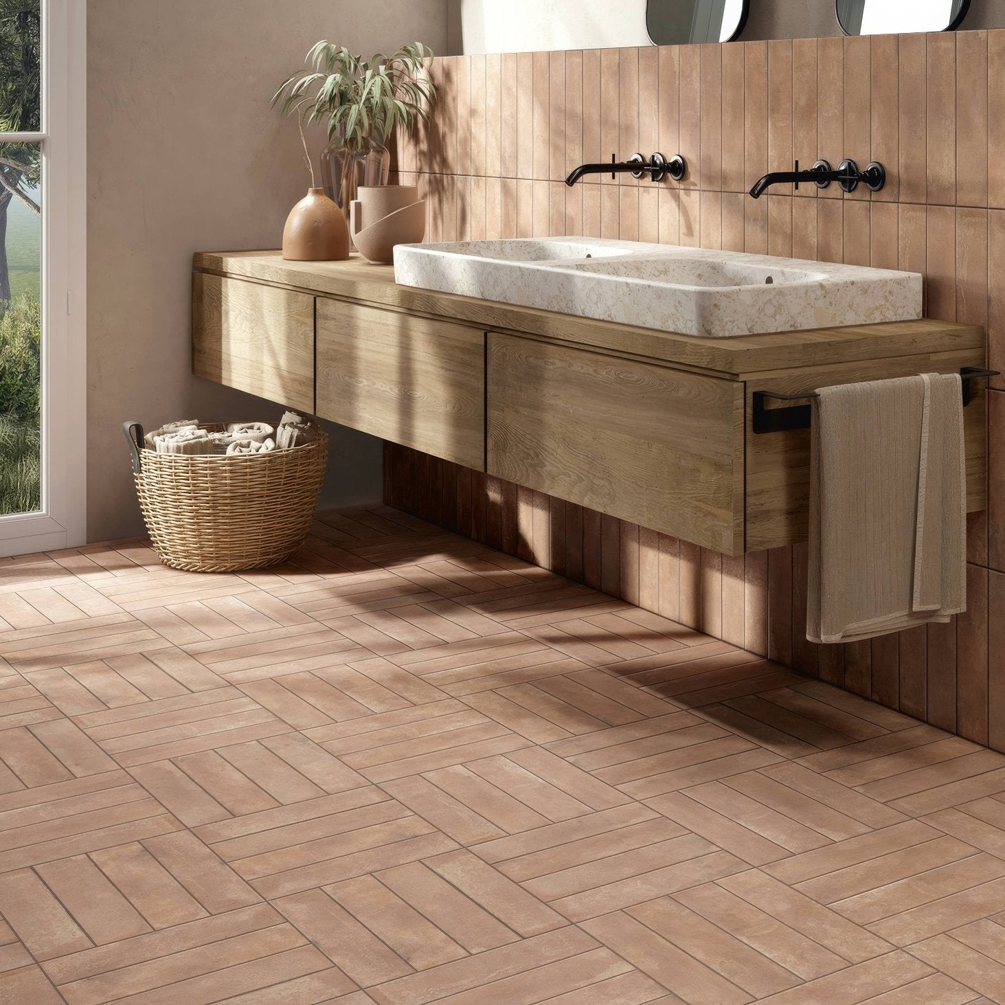 A rectangular white marble sink with gray veining set into a light wood vanity for the terracotta cotto porcelain collection
