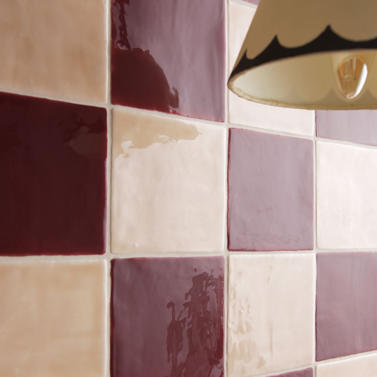 Thebes Field Tile mosaic wall featuring a glossy checkerboard pattern of burgundy cream and muted purple tiles