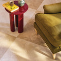 A glossy red cylindrical tibur cloud side table with a reflective surface perfect for modern living spaces