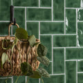 A woven natural fiber hanging basket with handle holding green and variegated leaves for tourmaline half tile wall tiles