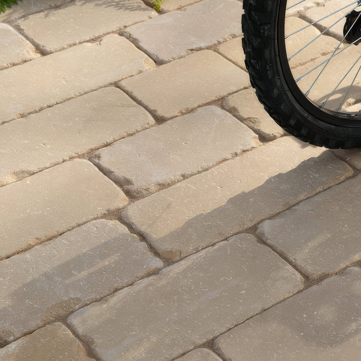 Beige rectangular tumbled sandstone pavers arranged in a staggered pattern from trafalgar sandstone tumbled cobbles