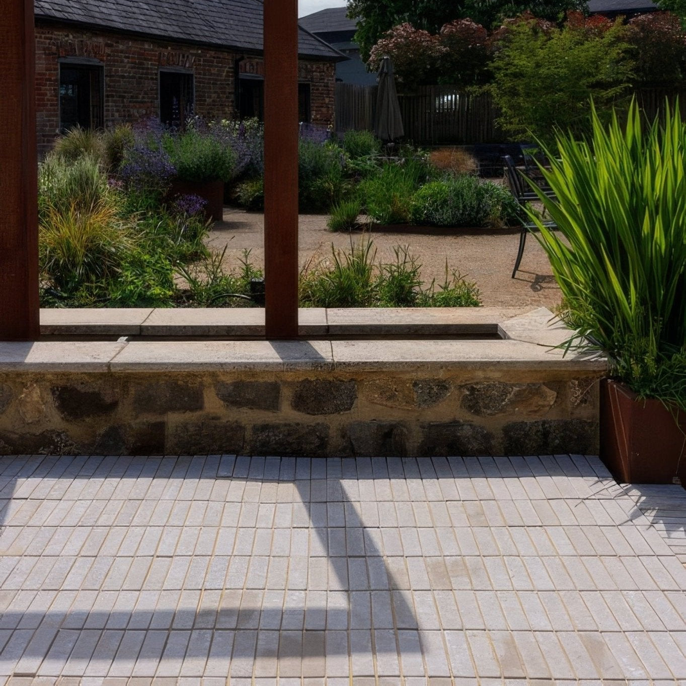 Light beige tumbled sandstone mosaic tiles paving a patio surface in trafalgar sandstone tumbled klinkers style