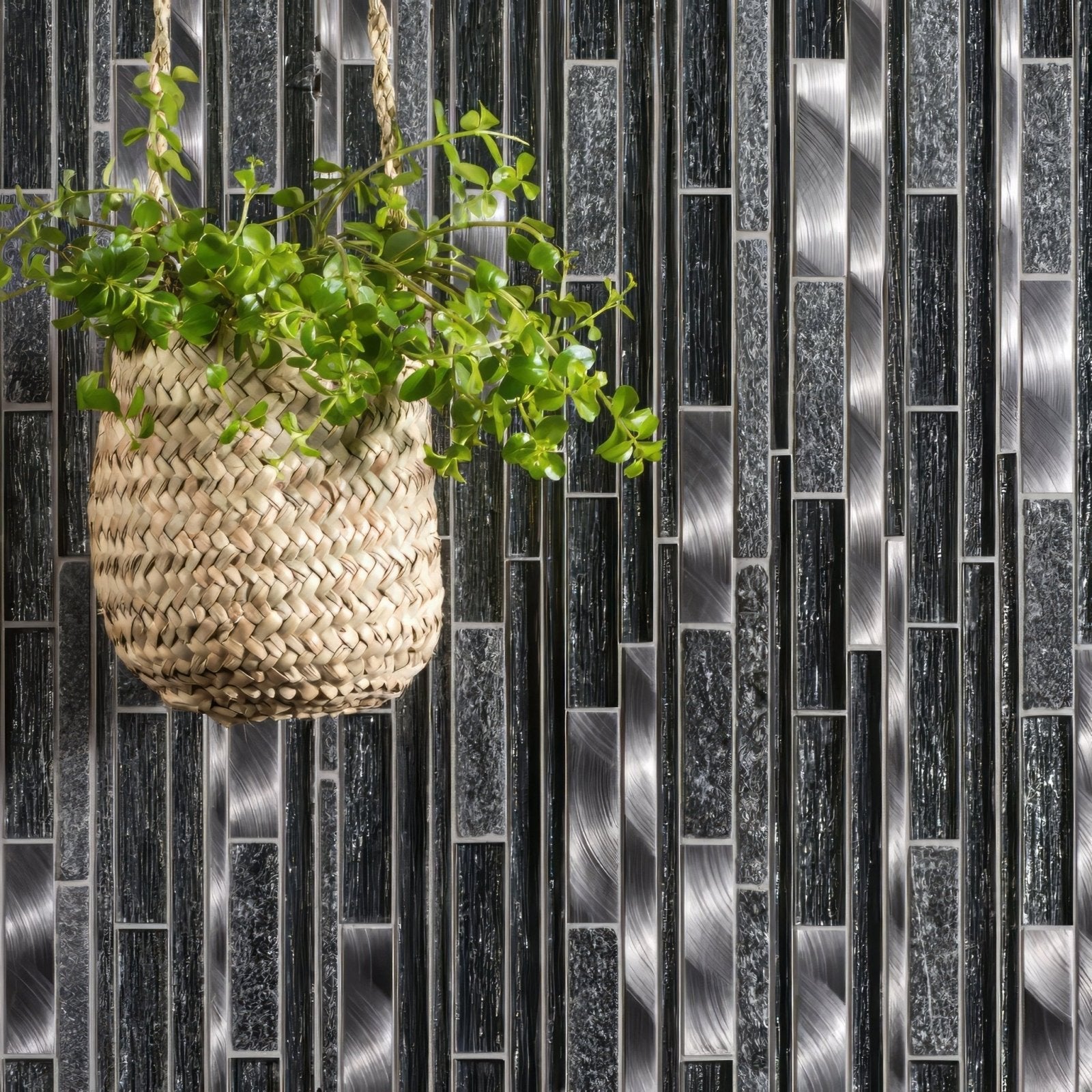 A woven beige hanging plant basket with green foliage in the tribune linear mixed material mosaic design