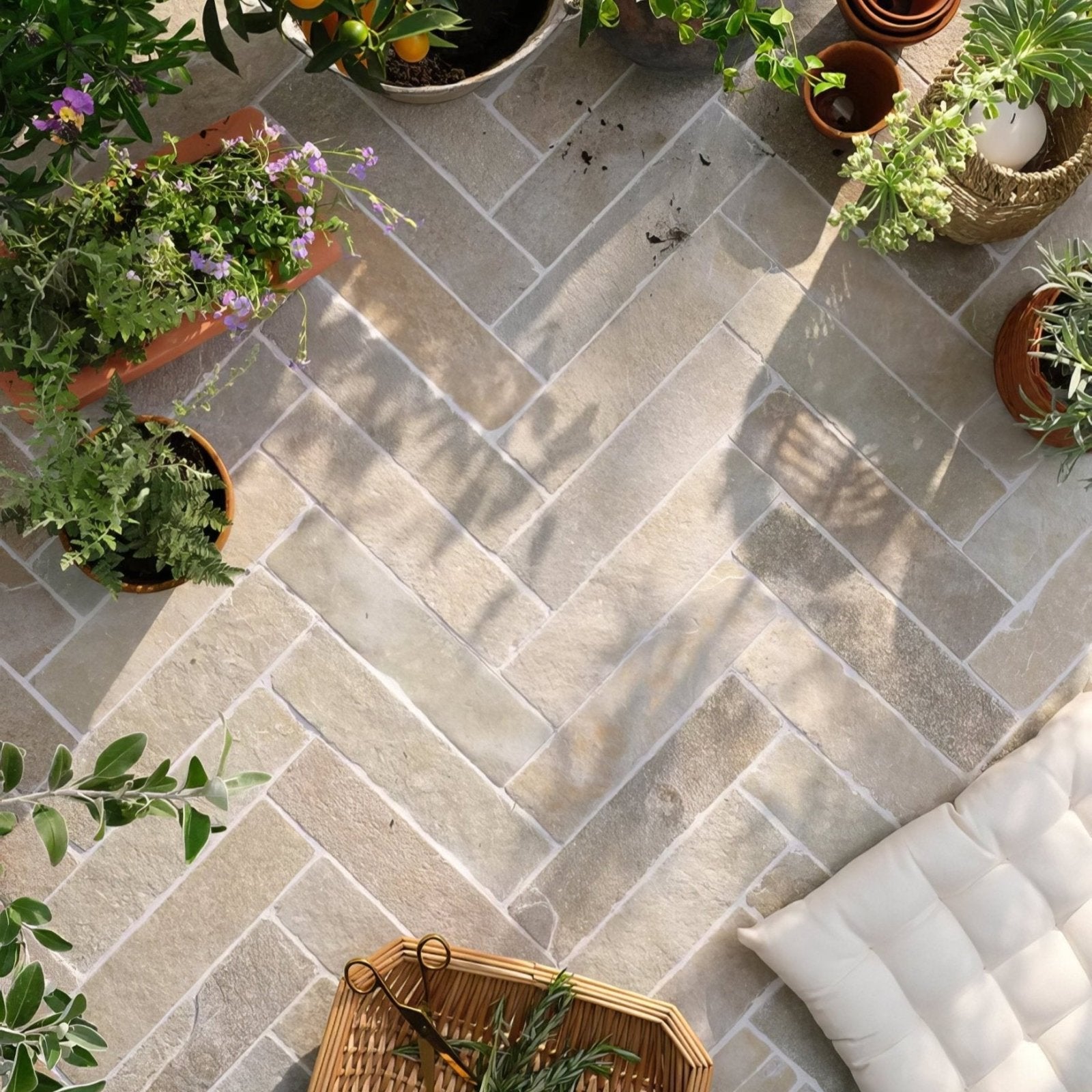 Light gray trusloe limestone seasoned finish parquet tiles arranged in a herringbone pattern