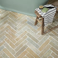 Herringbone-patterned Trusloe limestone seasoned finish parquet stone tiles in earthy beige and gray tones
