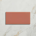 A rectangular terracotta-colored ceramic tile with a smooth matte finish from tunstall ceramic brick coral collection
