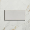 A sleek rectangular white ceramic Tunstall ceramic brick with a smooth matte finish on a marble surface