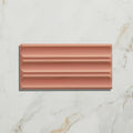 Tunstall ceramic fluted brick coral shows a copper-colored rectangular tile with a ribbed textured surface