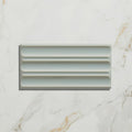 A sleek light gray ceramic fluted brick tile with a modern ribbed design for contemporary wall applications
