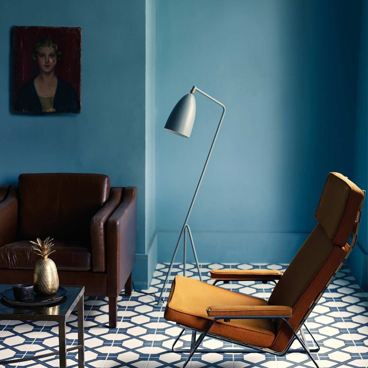 A sleek minimalist floor lamp in turkish blue with a metallic silver finish and an adjustable arm
