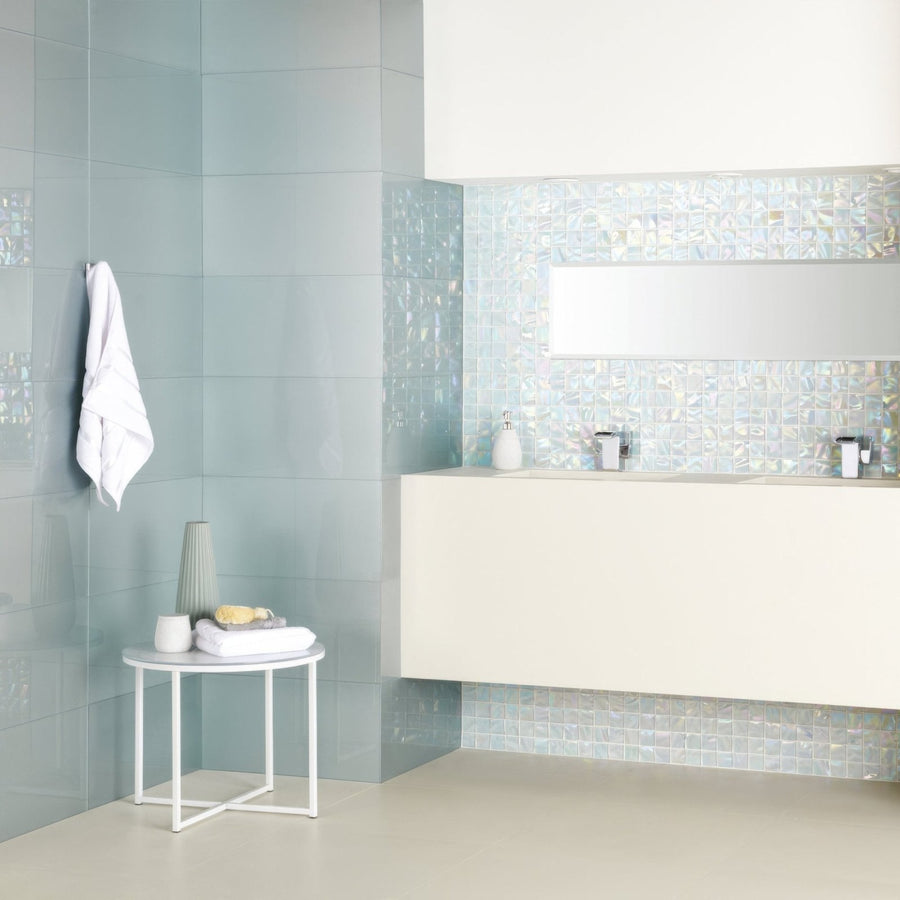The bathroom features light blue glossy tiles with a subtle textured finish in Ultimo Shell Iridescent Mosaic