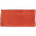 A glossy coral-colored rectangular ceramic vermillion half tile with rounded edges for wall or backsplash use