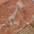 A warm terracotta versailles marble rouge honed surface with intricate white and gray veining pattern