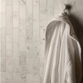 Viano White Honed Brickbond Mosaic white marble brick mosaic with a white waffle-weave bathrobe