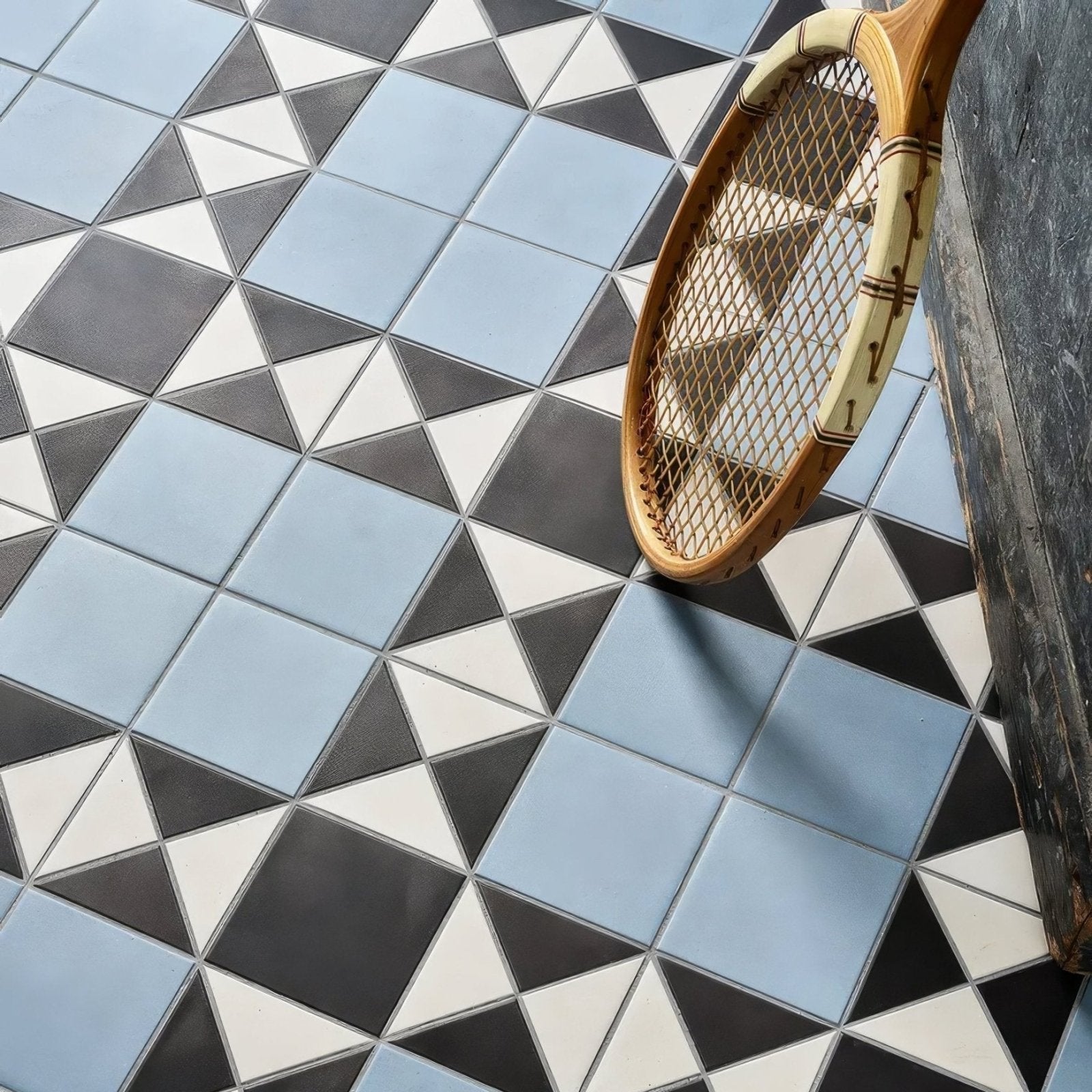 Victorian Style Porcelain Finchley Pattern Sky Blue blue geometric tiles with a vintage wooden tennis racket on a marble surface