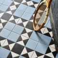 Victorian Style Porcelain Finchley Pattern Sky Blue blue geometric tiles with a vintage wooden tennis racket on a marble surface