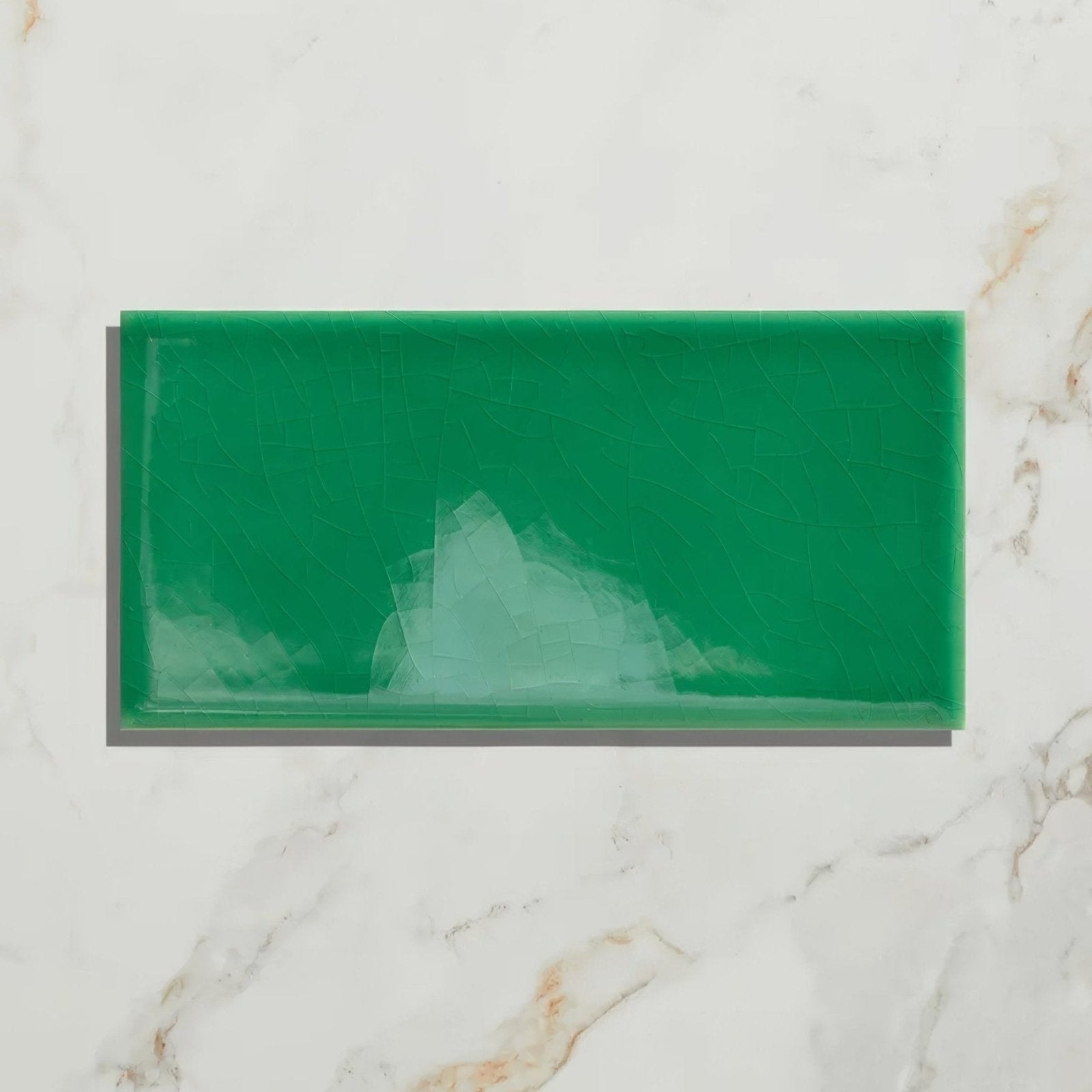 A rectangular emerald green ceramic wall tile with a glossy finish and subtle white veining from Victorian Style™