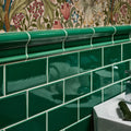 Victorian Style wall ceramic emerald green glossy subway tiles with white grout and a curved tile header detail