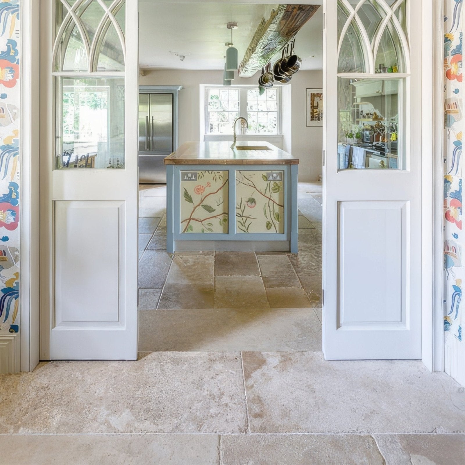 Blue kitchen island with floral patterned panels and wooden countertop in vieux bourgogne limestone ancient finish