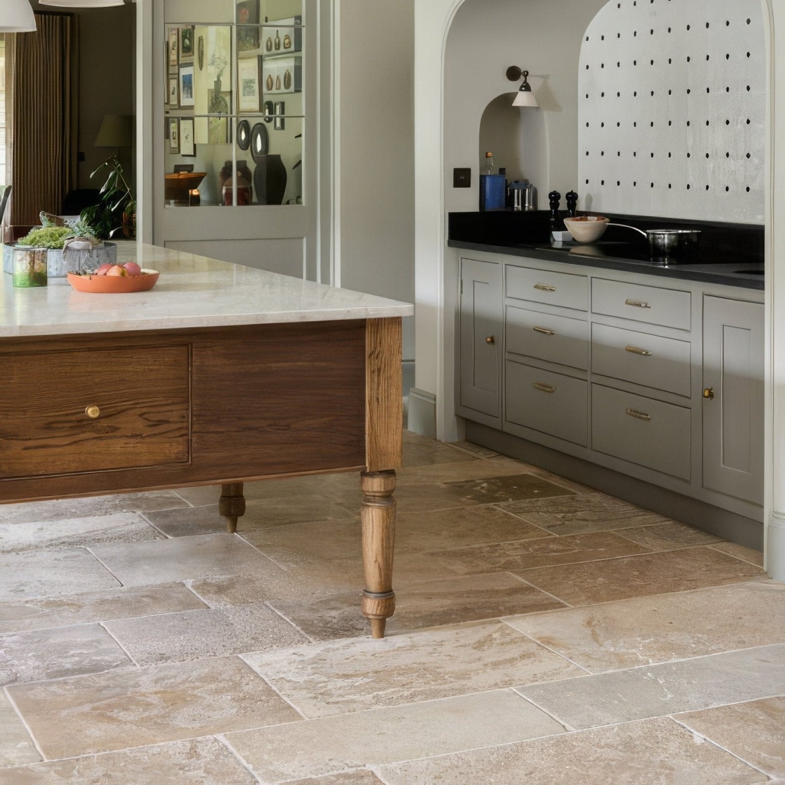 A rustic wooden kitchen island with turned legs and a white marble countertop in vieux bourgogne limestone ancient finish
