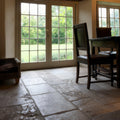 Stone floor tiles with rustic weathered texture and natural grayish beige tones in vieux bourgogne limestone artisan antiqued finish