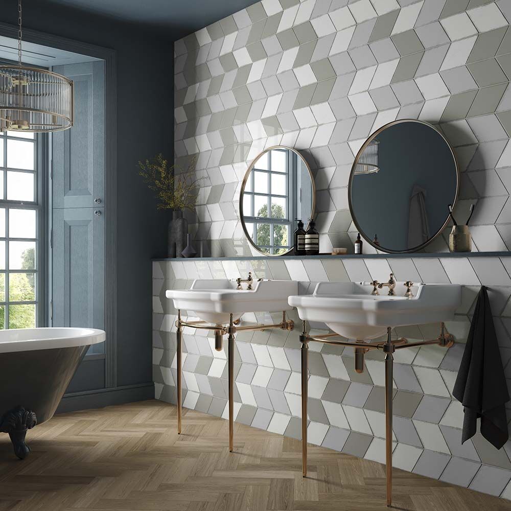 Two white ceramic vintage rhomboid pedestal sinks with brass metal legs and fixtures for bathroom use
