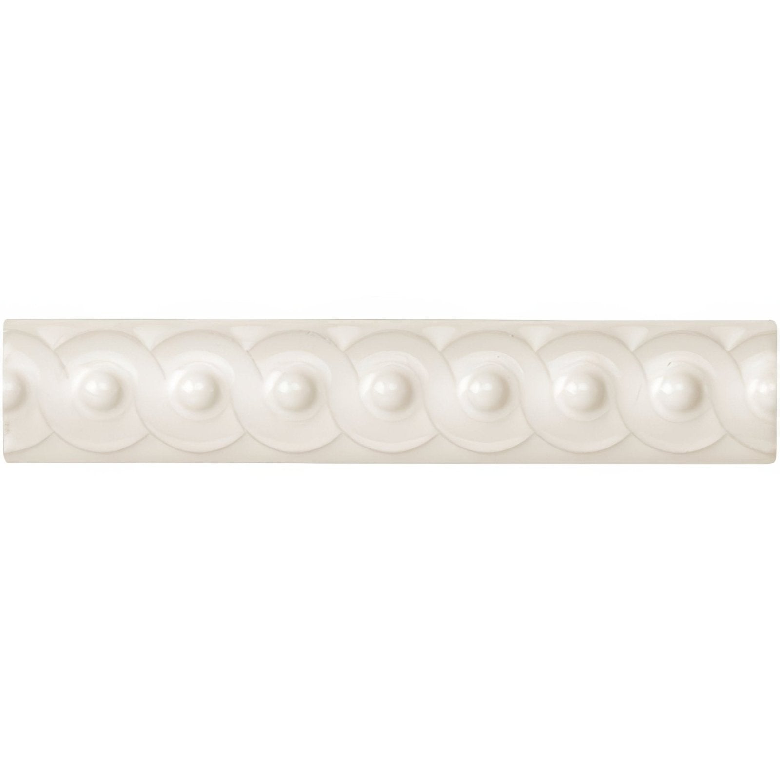 White ceramic vintage scroll moulding tile with raised rounded beads and circular motifs in a repeating pattern
