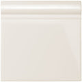 Vintage white skirting tile with cream-colored glossy ceramic baseboard and smooth rounded top edge for wall finishing