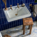 Vogue light blue stone white ceramic wall-mounted sink with brass fixtures and decorative gold chain drain cover