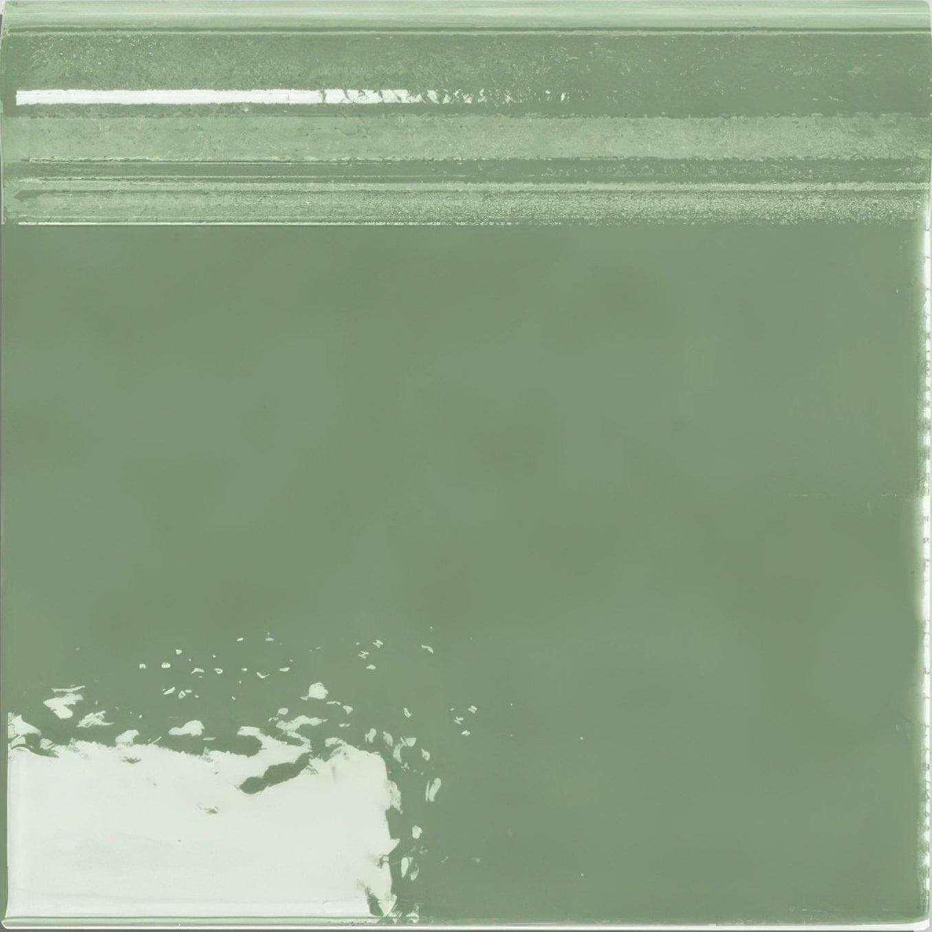A translucent sage green plastic bag with textured surface and visible seam containing victorian style wall ceramic cabbage green skirting