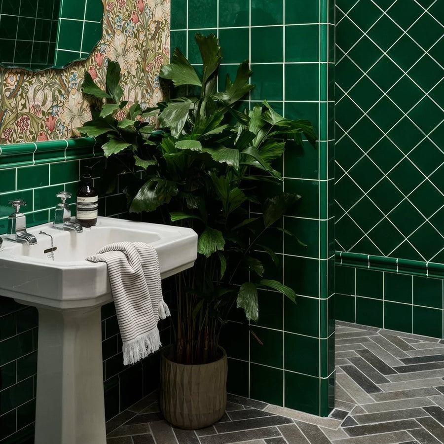 White ceramic pedestal sink with chrome fixtures and striped towel paired with Victorian Style wall ceramic emerald green tile