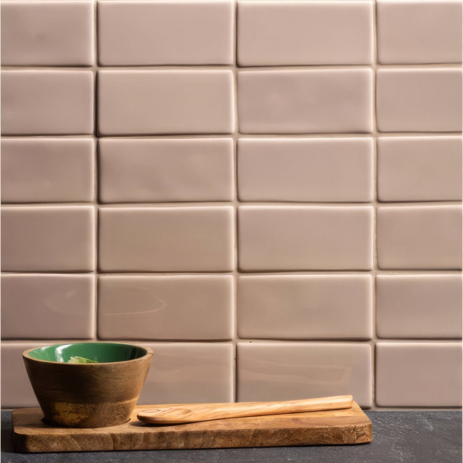 A walnut half tile rustic wooden bowl with a vibrant green interior on a natural wood cutting board