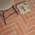 Wansdyke external terracotta floor tiles in rectangular shape arranged in a herringbone pattern with white grout lines