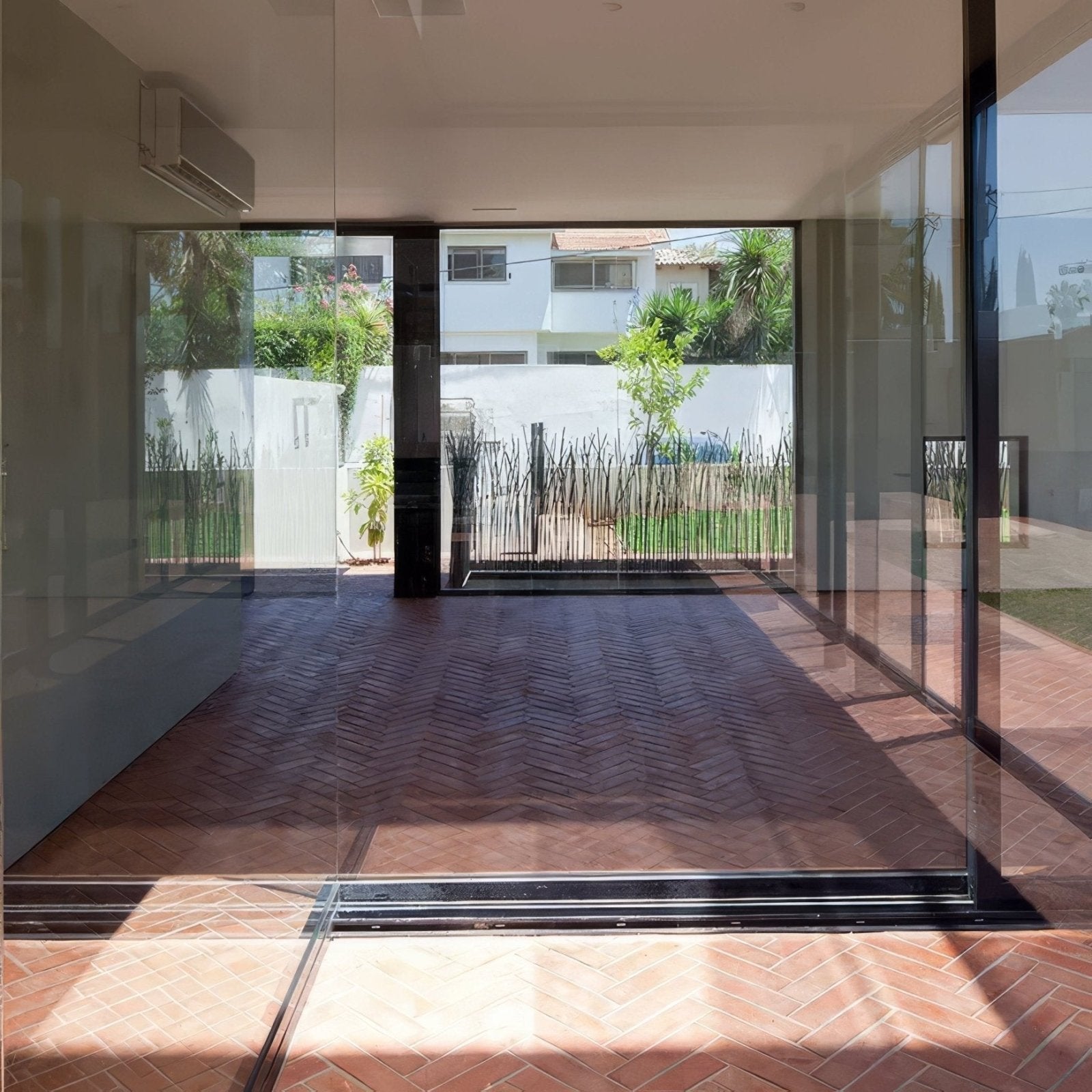 Wansdyke external terracotta modern glass sliding door with black metal frame opening to outdoor patio