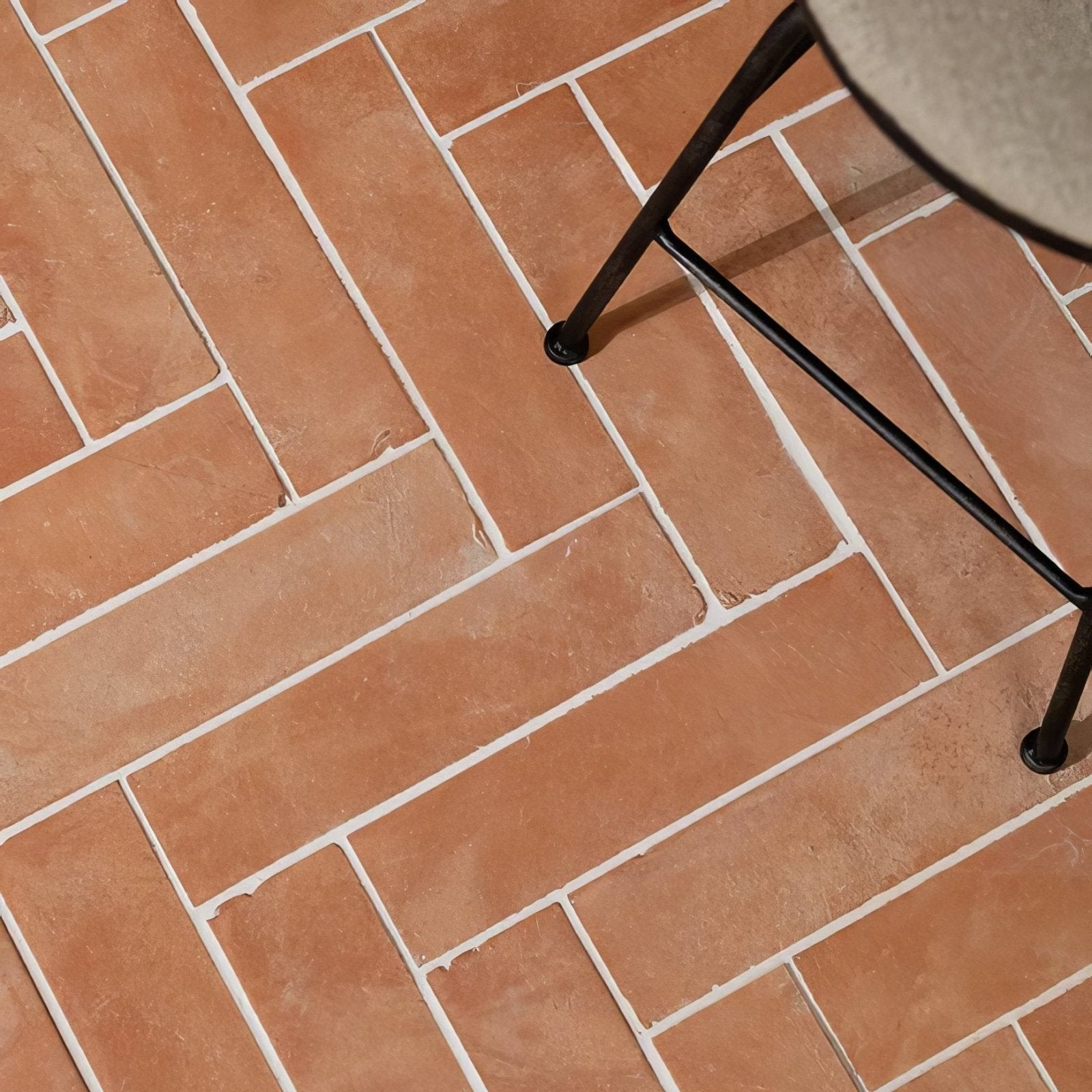 Wansdyke external terracotta rectangular floor tiles in terracotta color arranged in herringbone pattern with white grout