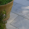 Terracotta planter with textured earthy brown surface and horizontal ridges in wareham limestone tumbled and etched finish