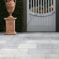 Terracotta urn with ornate floral carvings on a matching pedestal featuring wareham limestone tumbled and etched finish