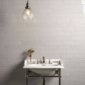 White ceramic pedestal sink with chrome fixtures and matching towel rack in westminster grey large brick setting