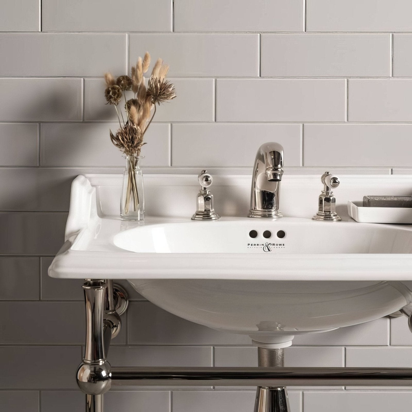 White ceramic perrin and rowe bathroom sink with polished chrome faucet and handles in westminster grey large brick setting