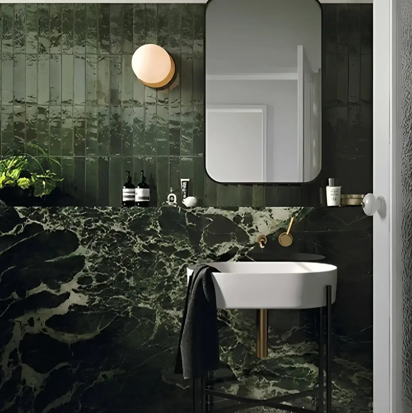 White oval sink with slender black metal legs and a gold-toned faucet.