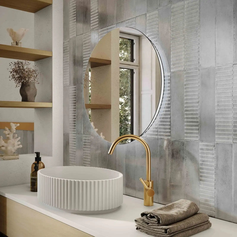White ribbed ceramic vessel sink with a gold-toned faucet